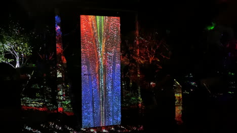 Person-reaching-for-door-handle-flooded-with-colourful-laser-lighting-in-outdoor-exhibition