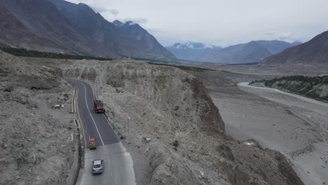 Aerial-View-of-Babusar-Mountain-Pass,-Pakistan,-Traffic-on-Scenic-Route,-Rocky-Hills-and-Snow-Capped-Peaks