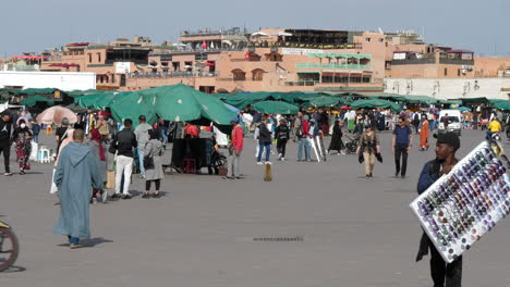Static-view-of-locals-and-tourists-strolling-in-the-busy-Jemaa-El-Fnaa-square-during-the-day