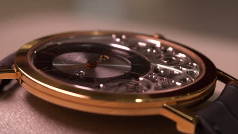 Lighting-shining-around-stylish-Piaget-gold-mechanical-wristwatch-with-leather-strap-close-up