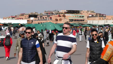 People-walking-around-Jemaa-El-Fna-crowded-market-square,-Marrakesh,-Morocco