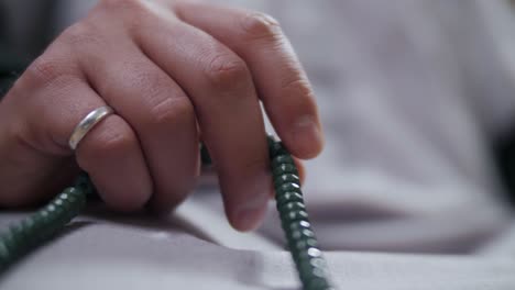 Close-up-of-practicing-Muslim's-hand-making-Tasbih-using-Misbaha