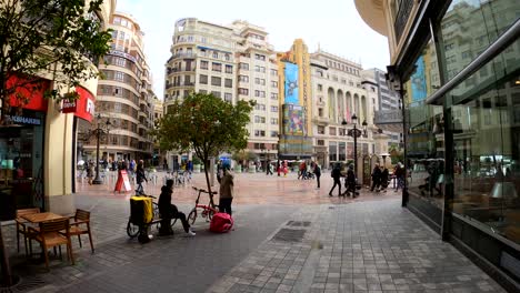 Foodpanda-and-Glovo-delivery-food-courier-taking-a-break-downtown-city-center-of-Valencia,-Spain