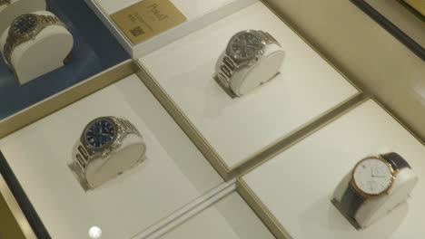 Panning-across-elegant-collection-of-Piaget-luxury-watches-in-stylish-Barcelona-store-counter-display