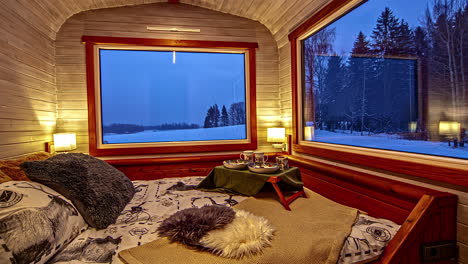 Comfortable-hotel-bedroom-with-large-panoramic-windows-on-rural-snowy-landscape