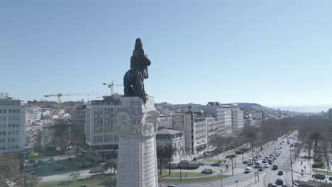 Aerial,-rising,-drone-shot,-tilting-towards-the-Marques-de-Pombal-statue-revealing-liberty-avenue-with-some-traffic,-in-Lisbon-city,-sunny-day,-in-Lisboa,-Portugal