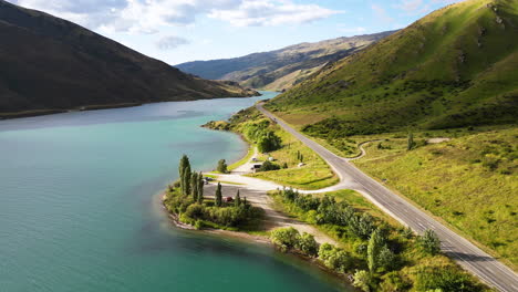 Country-asphalt-road-on-lake-of-coastline-of-New-Zealand,-aerial-drone-view