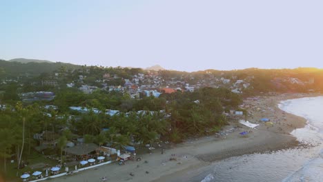 A-drone-flies-overhead-of-the-beach-in-Sayulita-Mexico-during-sunset