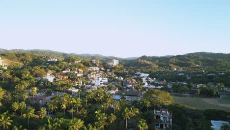 A-drone-rises-up-to-view-the-town-of-Sayulita,-Mexico-during-golden-hour