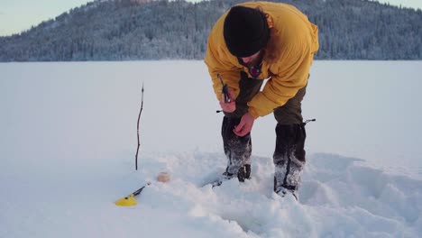 Pesca-En-Hielo---Hombre-Pescando-En-El-Lago-Congelado-Cubierto-De-Nieve