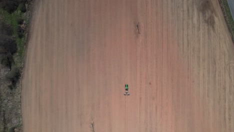 Tractor-in-Dusty-Agricultural-Field-Preparing-Land-For-Planting-Seeds,-Top-Down-Aerial-View