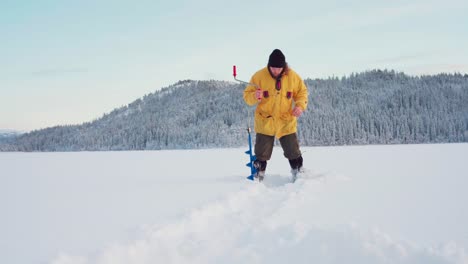 Male-Fisher-Drills-Hole-In-Ice-Using-Ice-Auger