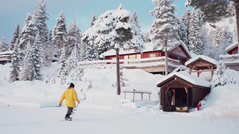 Winterliche-Ländliche-Landschaft-Mit-Einem-Mann,-Der-Eine-Bohrmaschine-Zur-Hütte-Trägt
