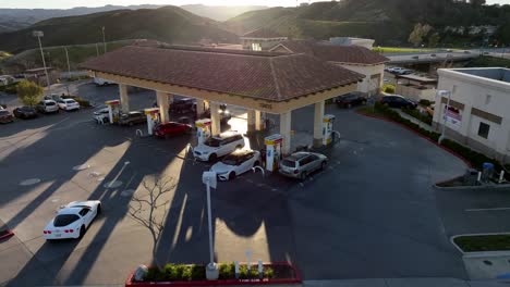 Cars-refueling-at-a-gas-station-at-sunset---ascending-aerial-view