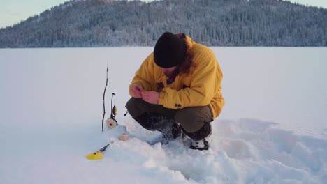 Hombre-Instalando-Su-Trampa-De-Pesca-En-Hielo-En-Un-Día-De-Invierno-En-Indre-Fosen,-Noruega---Ancho