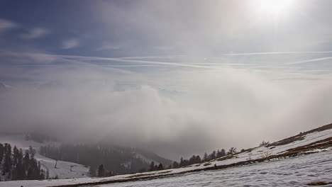 Snowy,-billowing-clouds-and-fog-over-a-winter-mountain-landscape---dynamic-time-lapse