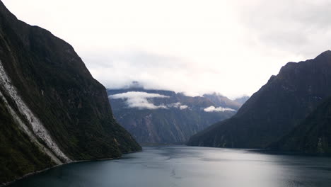 Lake-in-between-tall-mountain-ranges-in-Milford-Sound,-New-Zealand