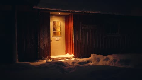 Beleuchtete-Tür-Einer-Hütte-In-Der-Nacht