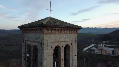 Majestic-aerial-drone-view-of-Fortunago-bell-tower,-rising-reveals-countryside
