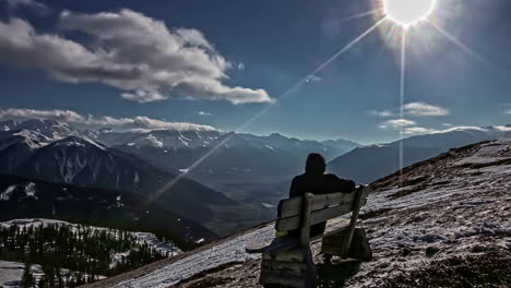 Hiker-in-a-high-mountain-peak-lookout-watches-the-scenery---time-lapse
