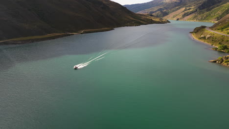 Aerial,-speedboat-sailing-on-mountain-valley-river,-turquoise-green-water