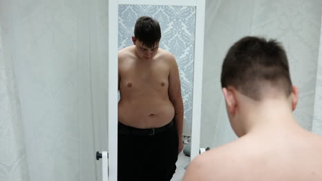Young-Fat-Man-Looking-at-His-Mirror-Reflection-and-Shaking-His-Belly
