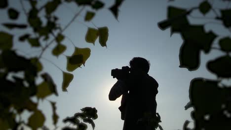 Silhouette-Eines-Männlichen-Fotografen,-Der-Fotos-Mit-Der-Sonne-Im-Hintergrund-Macht