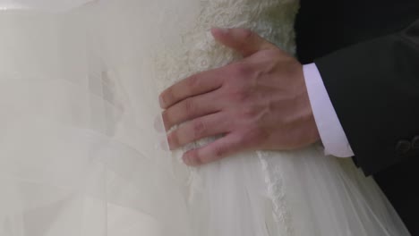 Groom-grabs-the-bride's-waist-at-their-wedding
