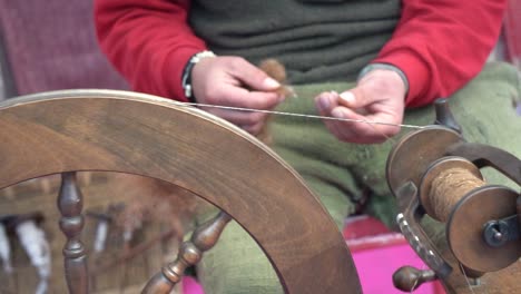 A-street-artist-sewing-manufacturing-with-traditional-spinning-wheel