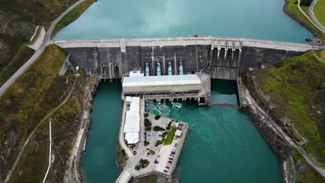 Clyde-Dam-building-complex-in-New-Zealand,-aerial-drone-orbit-view