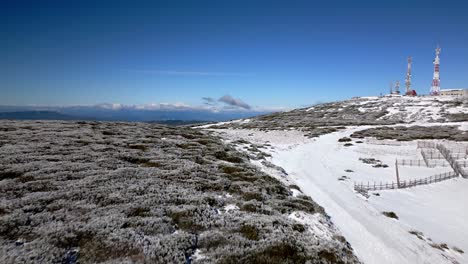 Luftaufnahme-über-Einem-Schneebedeckten-Berg-In-Richtung-Einiger-Antennen-Und-Der-Sicht-Auf-Den-Horizont-In-Manzaneda,-Galizien