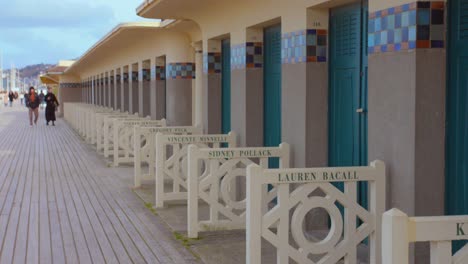 Normandy-Seaside-Beach-Huts-And-Wooden-Promenade-Les-Planches-With-Famous-Actors-And-Directors-Names-In-Deauville,-France