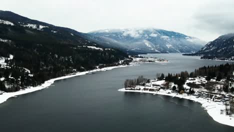 Peaceful-Winter-Scene-of-Adams-Lake-and-Snowy-Forests,-Aerial-View-with-Overcast-Sky