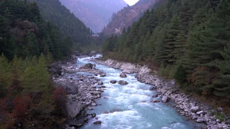 A-beautiful-glacier-river-running-in-the-valley-between-the-rugged-mountains-of-the-Himalayas-of-Nepal