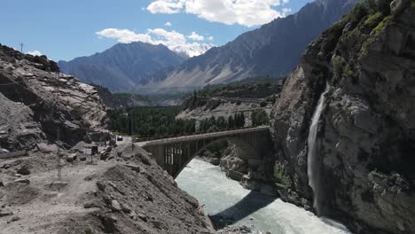 Aerial-View-of-Ganesh-Bridge-and-Waterfall-in-Hunza-Valley,-Pakistan,-Drone-Shot