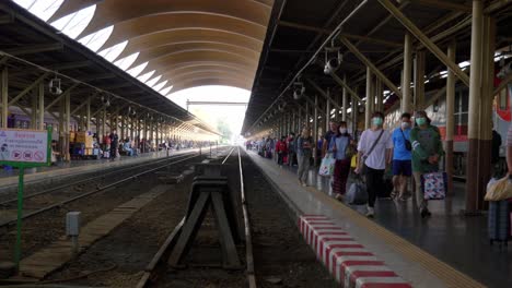 Train-passengers-arriving-and-departing-railway-station-on-platform,-Bangkok,-Thailand