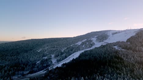 Panoramic-shot-flying-over-a-snowy-forest-in-a-mountainous-landscape-in-Manzaneda,-Galicia