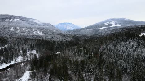 Snow-Covered-Forest-and-Majestic-Mountains-Surround-the-Adams-River-on-an-Overcast-Day