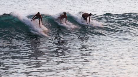 Surfers-share-wave-and-ride-over-glistening-water