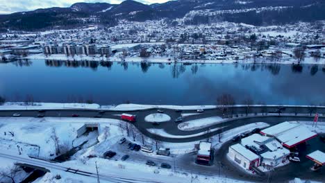 Afternoon-traffic-in-a-roundabout-near-the-river-Drammenselva,-Viken,-Norway