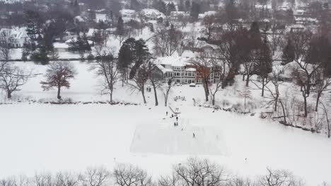 Aerial,-family-and-friends-skating-on-a-homemade-backyard-ice-hockey-rink