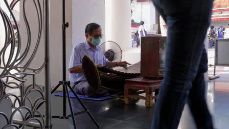 Hombre-Asiático-Con-Máscara-Tocando-El-Instrumento-Musical-Ranat-Thai-Xilófono-En-El-Templo-Budista