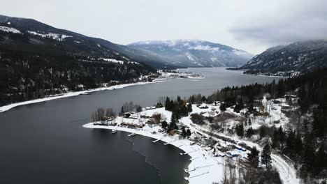 Tranquilo-Paisaje-Invernal-Del-Lago-Adams-Y-Bosques-Nevados,-Disparo-De-Drones-Con-Cielo-Nublado