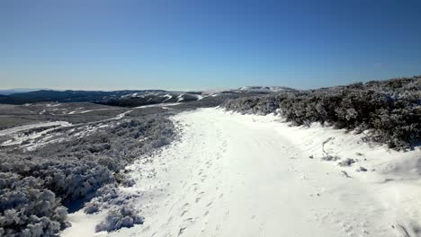 Luftaufnahme-über-Einem-Verschneiten-Gebiet-Auf-Einem-Berg-Und-Dem-Horizont-Mit-Bergen-Im-Hintergrund-In-Manzaneda,-Galizien