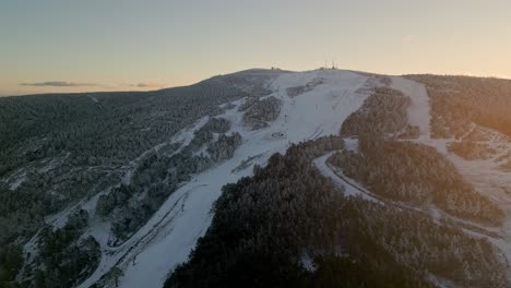 Cinematic-aerial-shot-flying-over-a-snowy-mountain-pass-at-sunset-in-Manzaneda,-Galicia