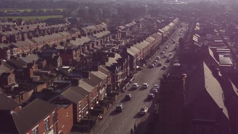 Aerial-rising-view-establishing-rows-of-Victorian-terraced-houses-in-Dentons-Green,-St-Helens-with-a-long-road-leading-towards-the-bustling-town-centre