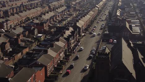 Aerial-rising-view-establishing-rows-of-terraced-houses-in-Dentons-Green,-St-Helens-with-a-long-road-leading-towards-the-bustling-town-centre