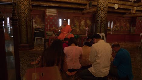 Monje-Budista-Bendiciendo-A-La-Gente-Salpicando-Agua-Sobre-Sus-Cabezas-En-La-Ceremonia-De-Songkran,-Tailandia
