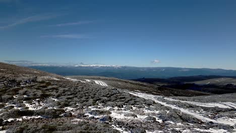 Panoramic-shot-of-a-snowy-mountain-system-and-the-blue-sky-on-the-horizon-of-Manzaneda,-Galicia