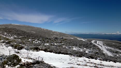 Panoramic-shot-over-a-snowy-mountain-and-on-the-horizon-the-sea-in-Manzaneda,-Galicia
